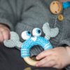 Gehäkelte Babyrassel Krabbe PINCER in Türkis mit Babyhand