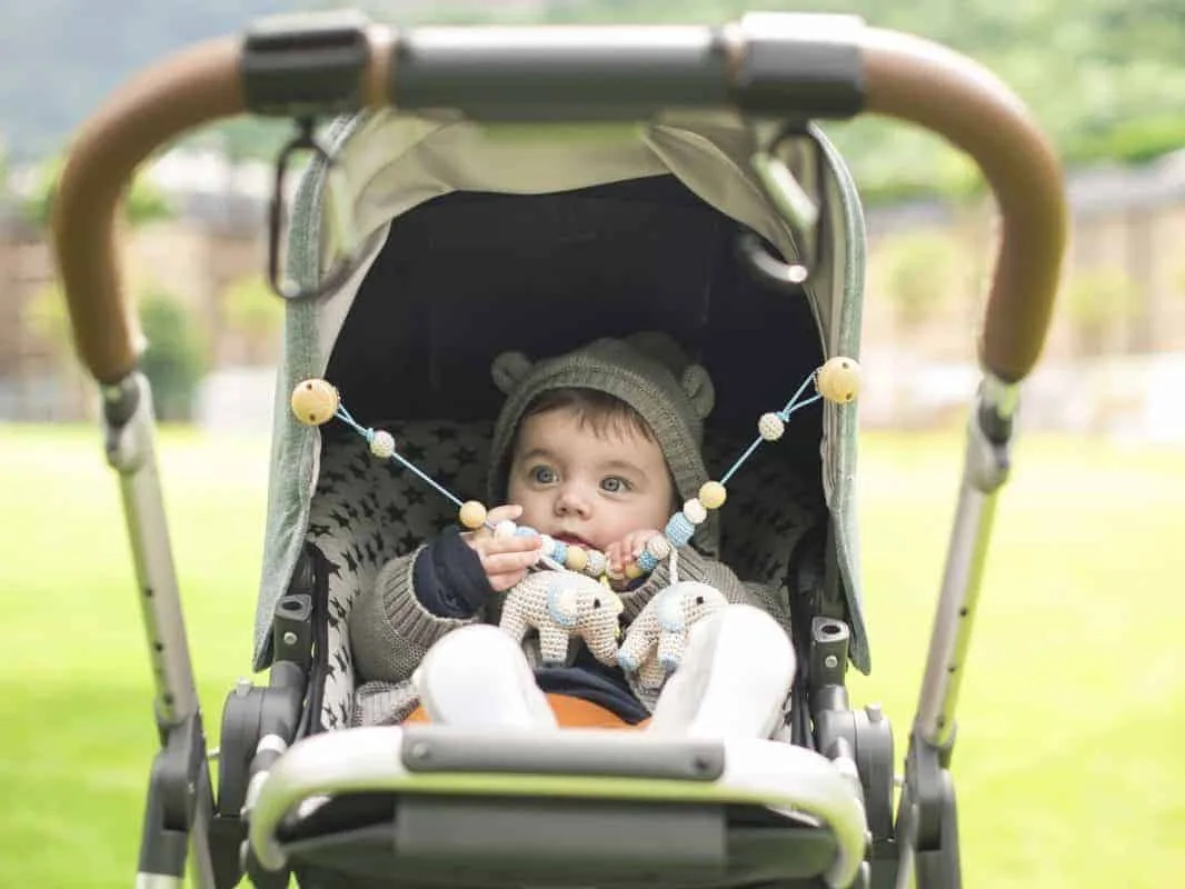 Baby im Kinderwagen mit Babyspielzeug