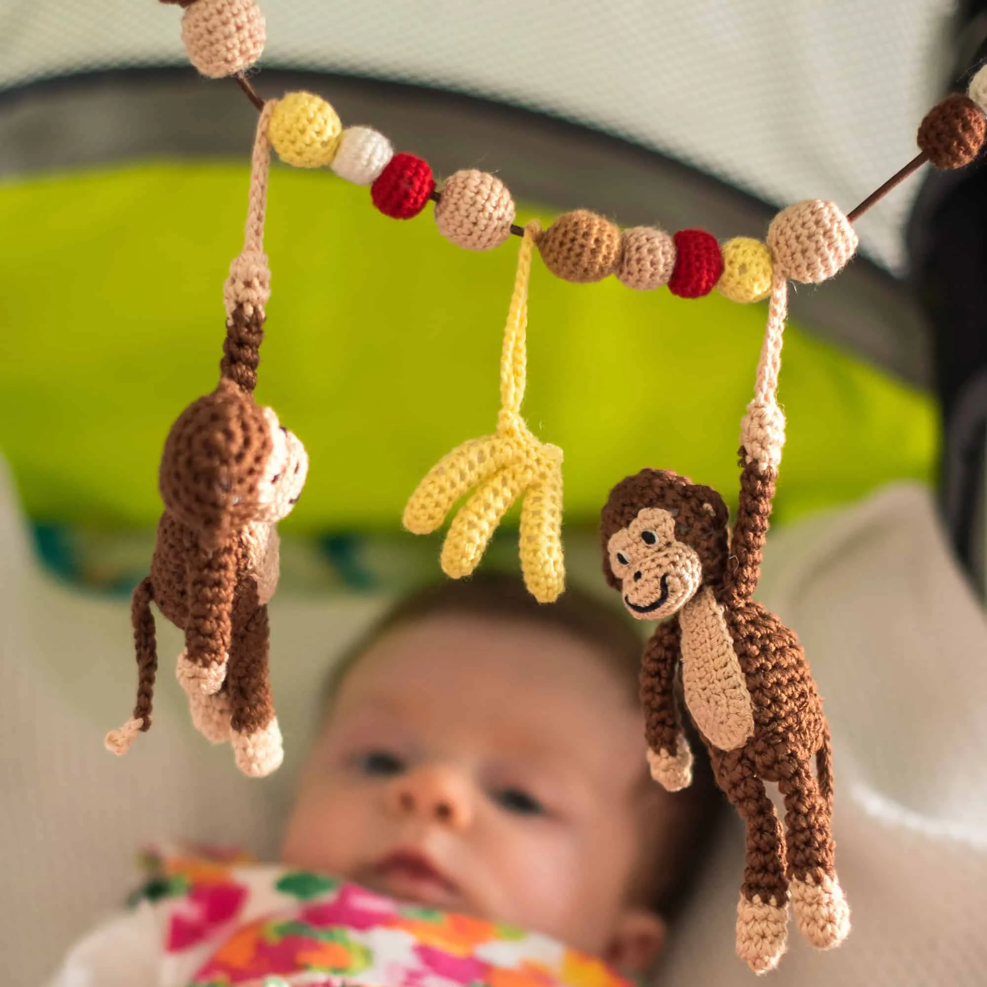 Gehäkelte Kinderwagenkette Affe CHARLIE in Braun - mit Baby im Kinderwagen