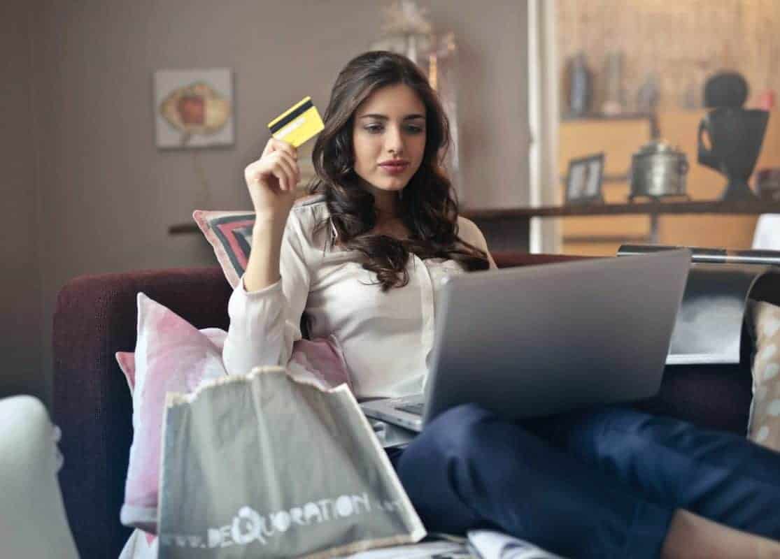 Frau mit Kreditkarte und Laptop beim Online-Shopping
