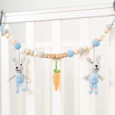 Gehäkelte Kinderwagenkette personalisiert mit BAEKHO am Kinderbettchen